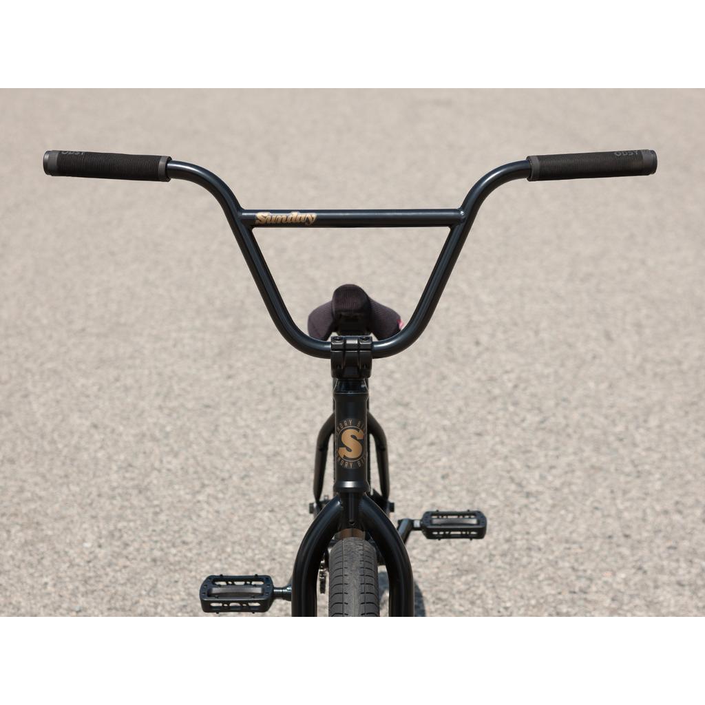 Close-up front view of the 2025 Sunday Forecaster 20 Inch BMX Bike (Broc Raiford) in black chromoly with wide handlebars on pavement, featuring the Odyssey Clutch v2 Freecoaster.