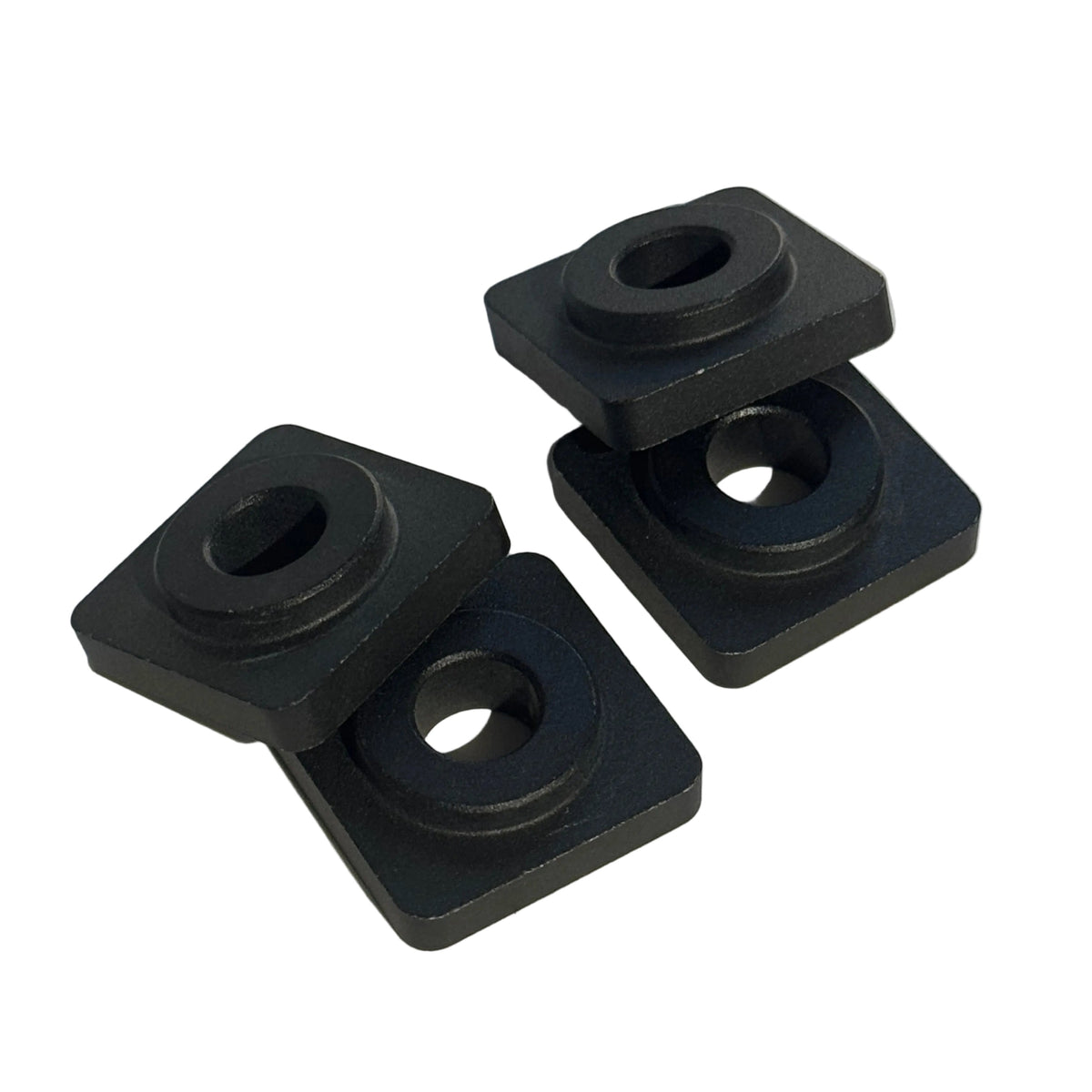 Two black, rectangular metal pieces with circular holes, angled and positioned side by side on a light surface—these are Speedco M2 Dropout Adapters, perfect as replacement dropout adapters for your bike.