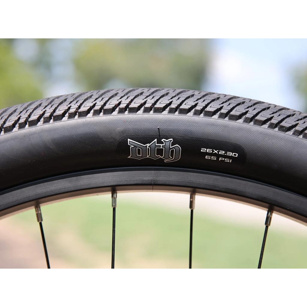 Close-up of a Fairdale Hareraiser FX 26 Inch Bike tire on its DJ frame, highlighting the tread and sidewall markings: "DTH," "26x2.30," and "65 PSI.