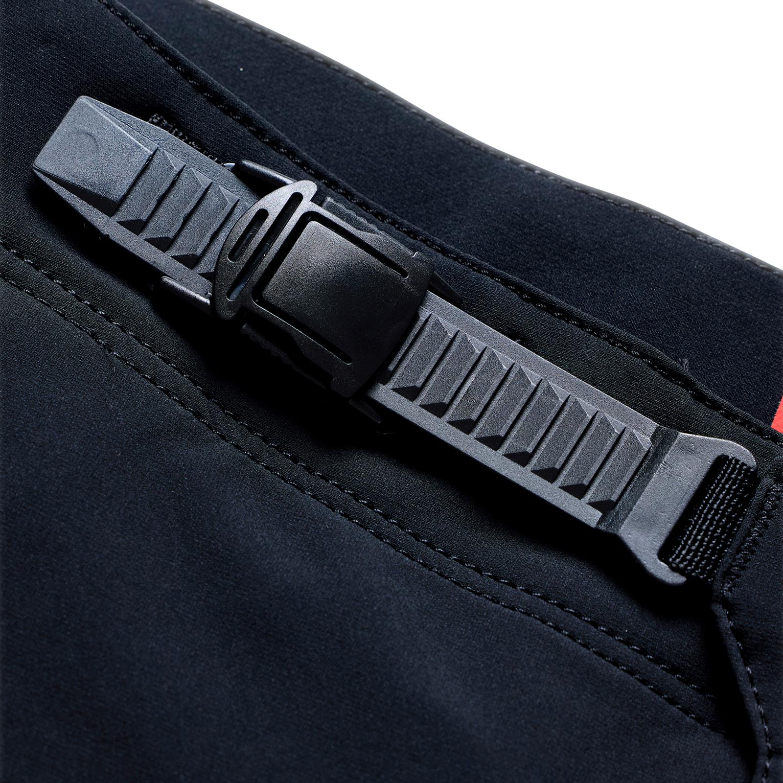 Close-up of the TLD 26.1 Sprint Pro Pants / Mono Black’s black plastic buckle fastener on a dark lightweight poly mesh strap, highlighting stitching and texture details for optimal ventilation.