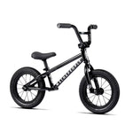 A black children's balance bike with thick tires, a padded seat, and "Wethepeople Prime Balance BMX Bike" written on the frame is perfect for young BMX enthusiasts.