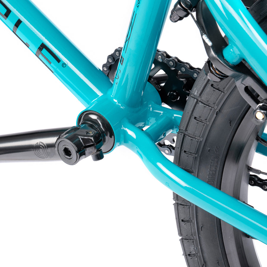 A close up of a turquoise Wethepeople Nova 20 Inch BMX Bike with black brakes.