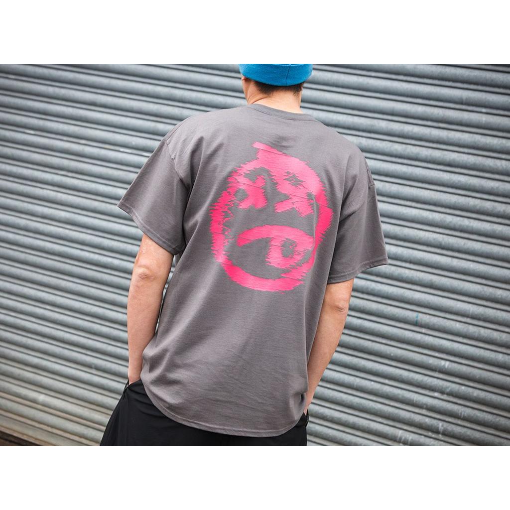 Person wears a gray BSD Tuned Out T-Shirt with a large pink abstract graphic on the back, standing in front of a metal roller shutter—ideal for streetwear style.