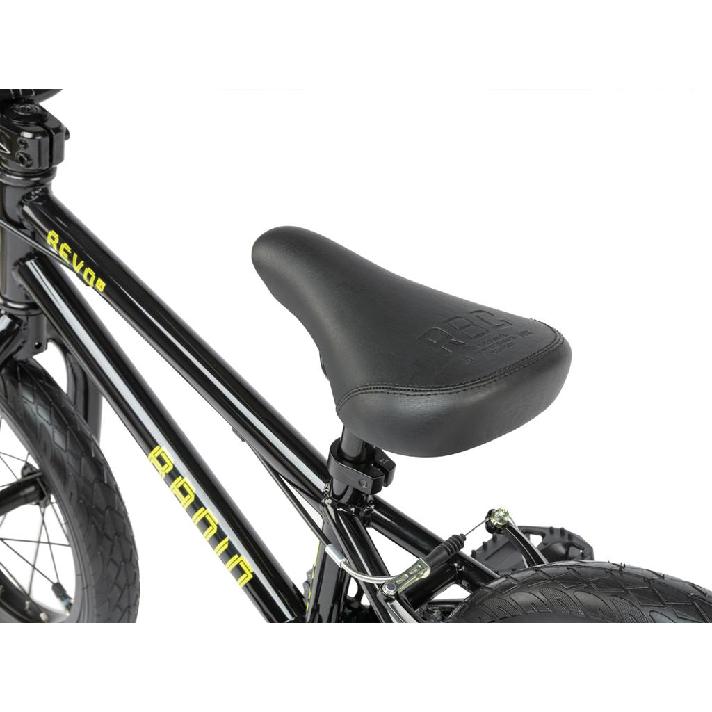 Close-up of a black Radio Revo 14 Inch bike, highlighting the padded seat and frame with yellow lettering—ideal for anyone choosing their first BMX.