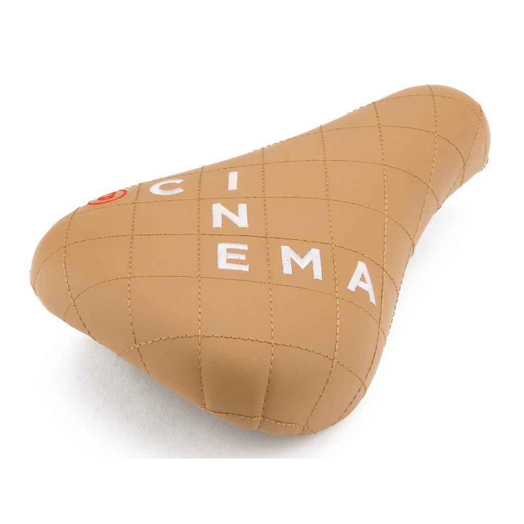 Cinema Blocked Stealth Seat: Tan faux leather bike seat with stitched grid pattern and "CINEMA" in white letters on top.