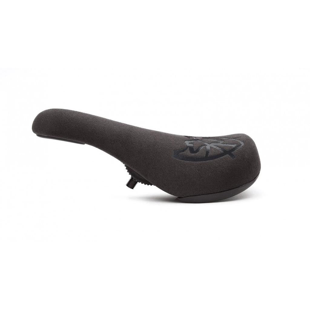 Side view of the S&M Stealth Slim Pivotal Seat in black, featuring a textured surface, top logo, ergonomic design, and bolt for seat post attachment.