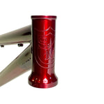 Close-up of the S&M Big Jumper V2 26 Inch Dirt Jumper Frame's metallic red head tube, featuring an embossed S&M logo and shield, built for suspension forks and disc brake compatibility.