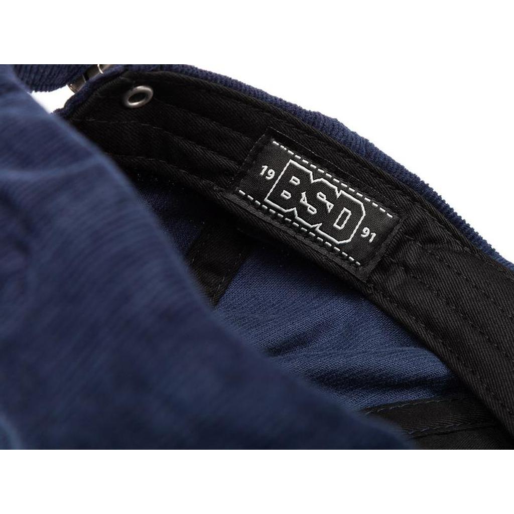 Close-up of the BSD More Speed Cap in navy blue, showing a black fabric label with "BSD 1991" in white text.