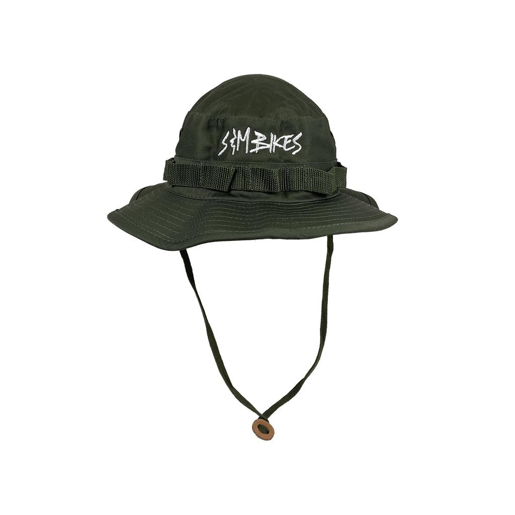 The S&M Boonie Bucket Hat features an olive green military style, chin strap, crown webbing detail, and a white stylized front logo—offering a modern twist on the classic bucket hat.