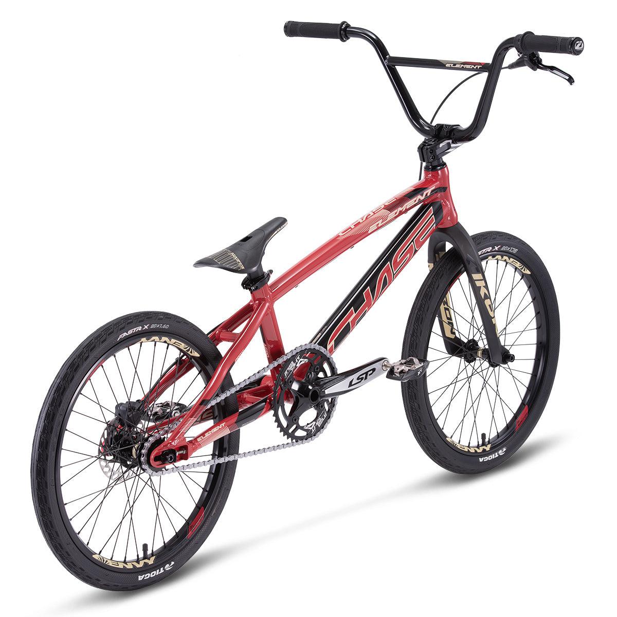 Side view of the Chase Element Pro L Bike, a red BMX race bike featuring black handlebars and wheels. Equipped with a silver chain, black grips, Ikon carbon forks, and prominently displaying the "Chase Element" branding on its frame.