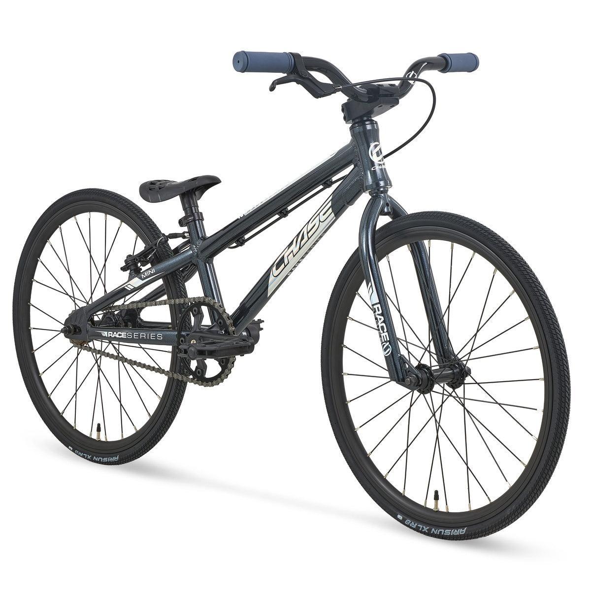 The Chase Race Series Mini Race Bike (2027), featuring a black BMX-style frame, blue handlebars, narrow tires, and a lightweight build—ideal as an entry-level BMX—is displayed on a white background.
