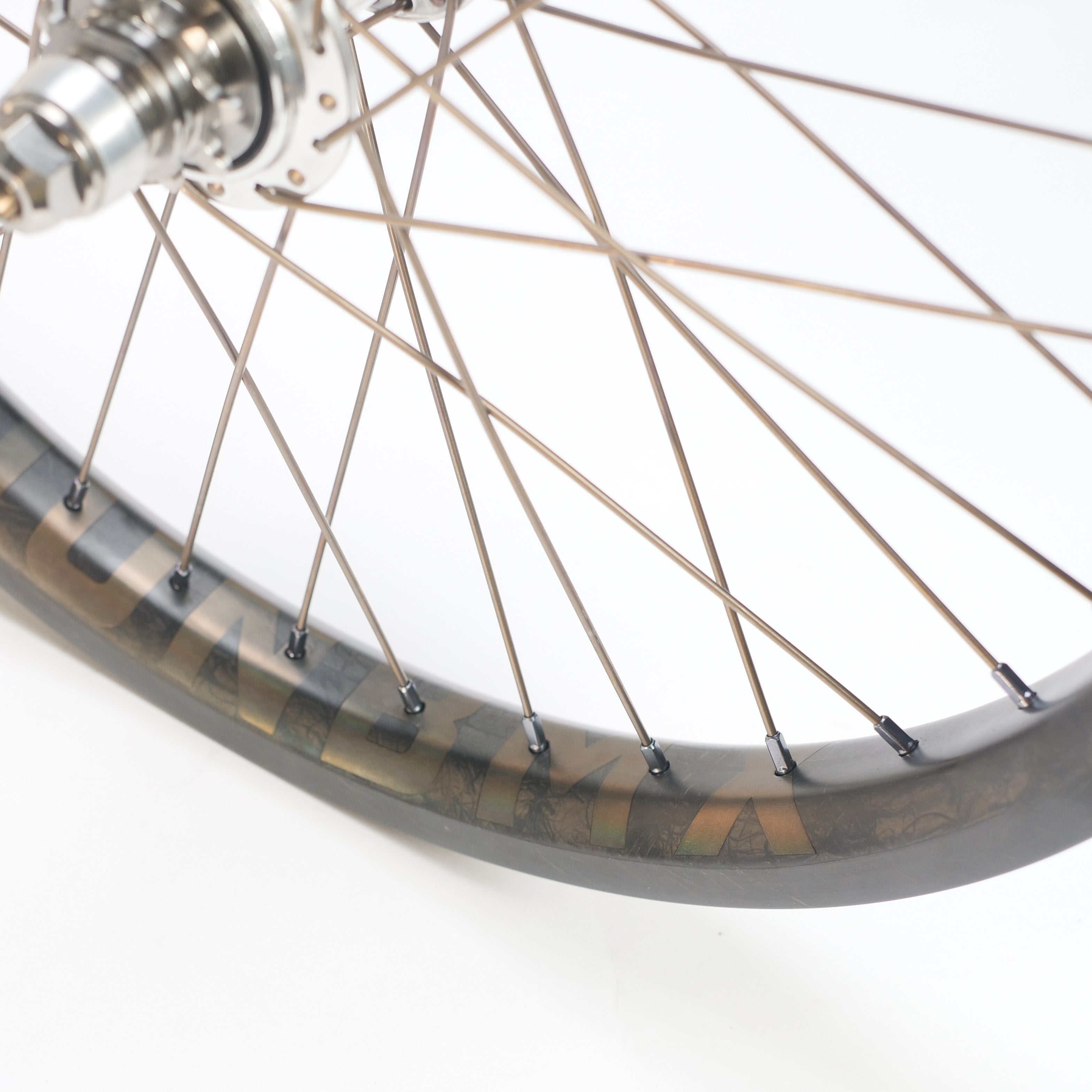 Close-up of the ION BMX C20 Carbon Titanium V1.5 Planetary 20 Inch Wheelset, showcasing its titanium spokes, hub, and rim section against a white background.
