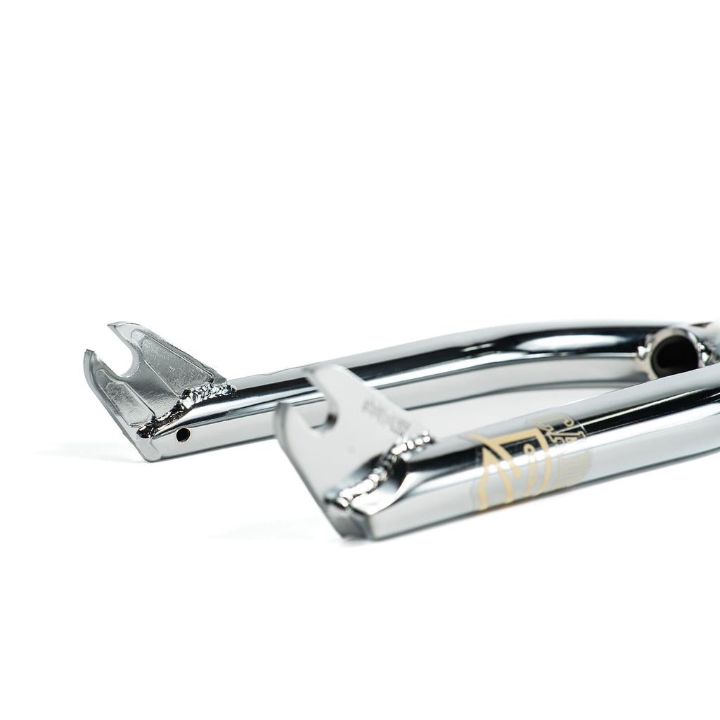 Close-up of two Colony Cadet 16 Inch Forks' chrome dropouts with visible welds and a reflective finish, highlighting the heat-treated CrMo construction and BMX 25mm offset.