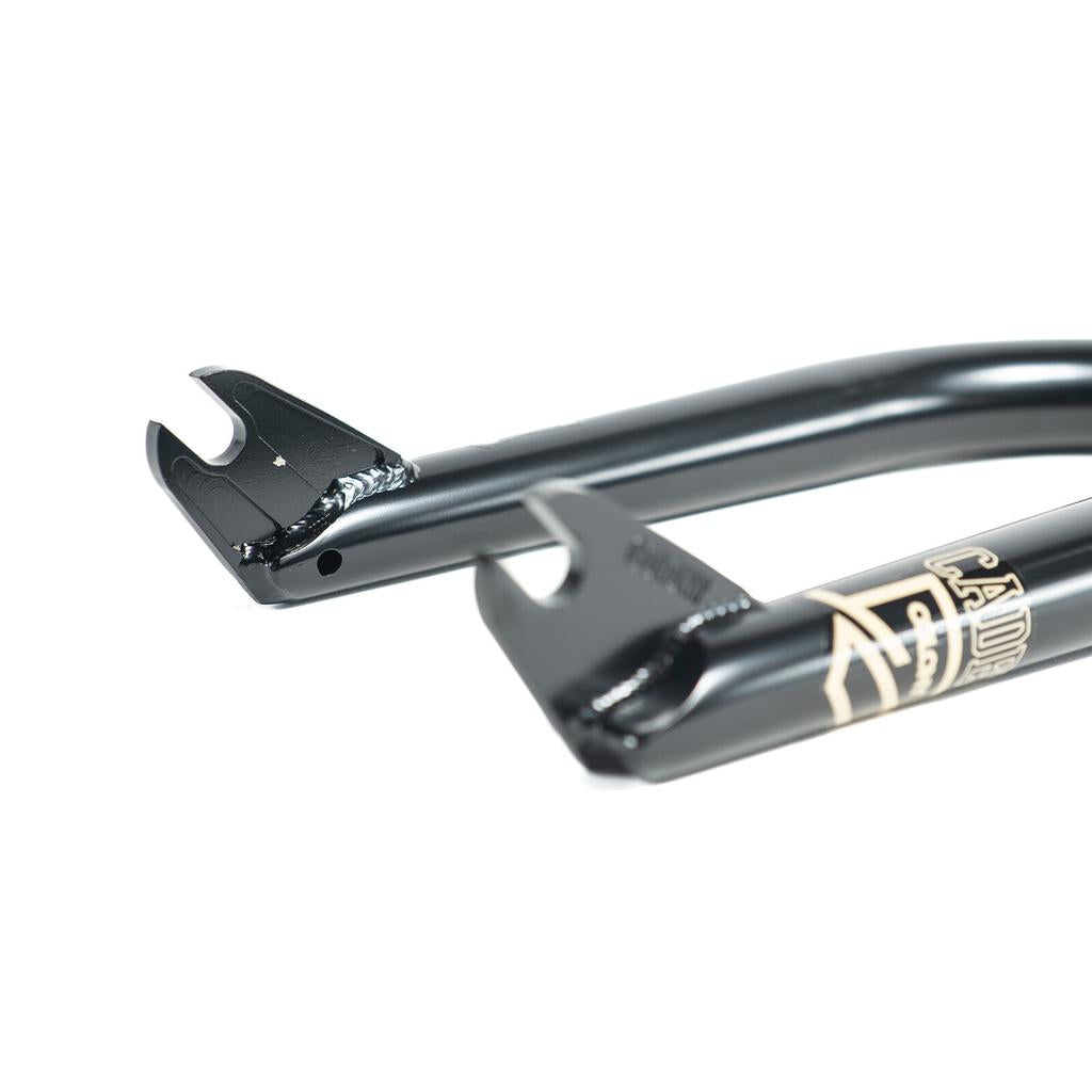 Close-up of the dropout ends on Colony Cadet 18 Inch Forks, featuring visible welds and a gold and white logo—showcasing these quality BMX forks.