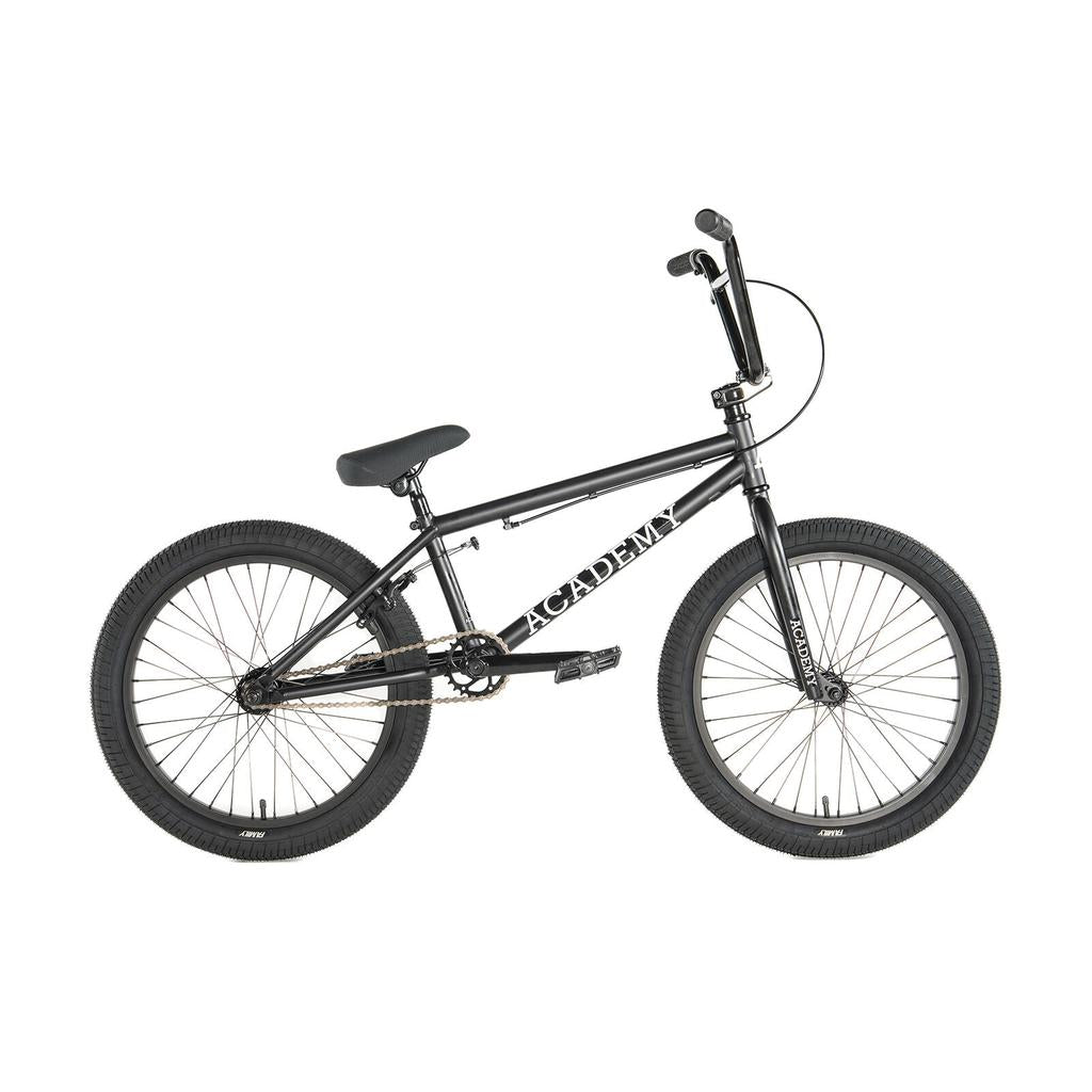 The Academy Trooper 20 Inch Bike is a black beginner BMX with a straight top tube, thick tires, and "ACADEMY" on the frame—shown in side profile. Ideal for youth or anyone seeking a BMX bike for tricks.