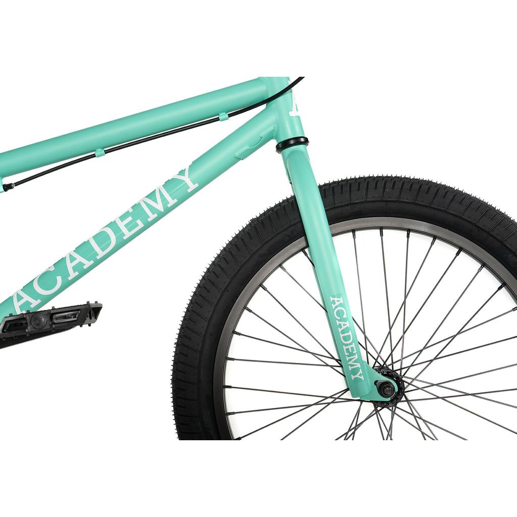 Close-up of the Academy Trooper 20 Inch Bike in teal, highlighting the front wheel, tire, pedal, and part of the frame with "ACADEMY" in white text.