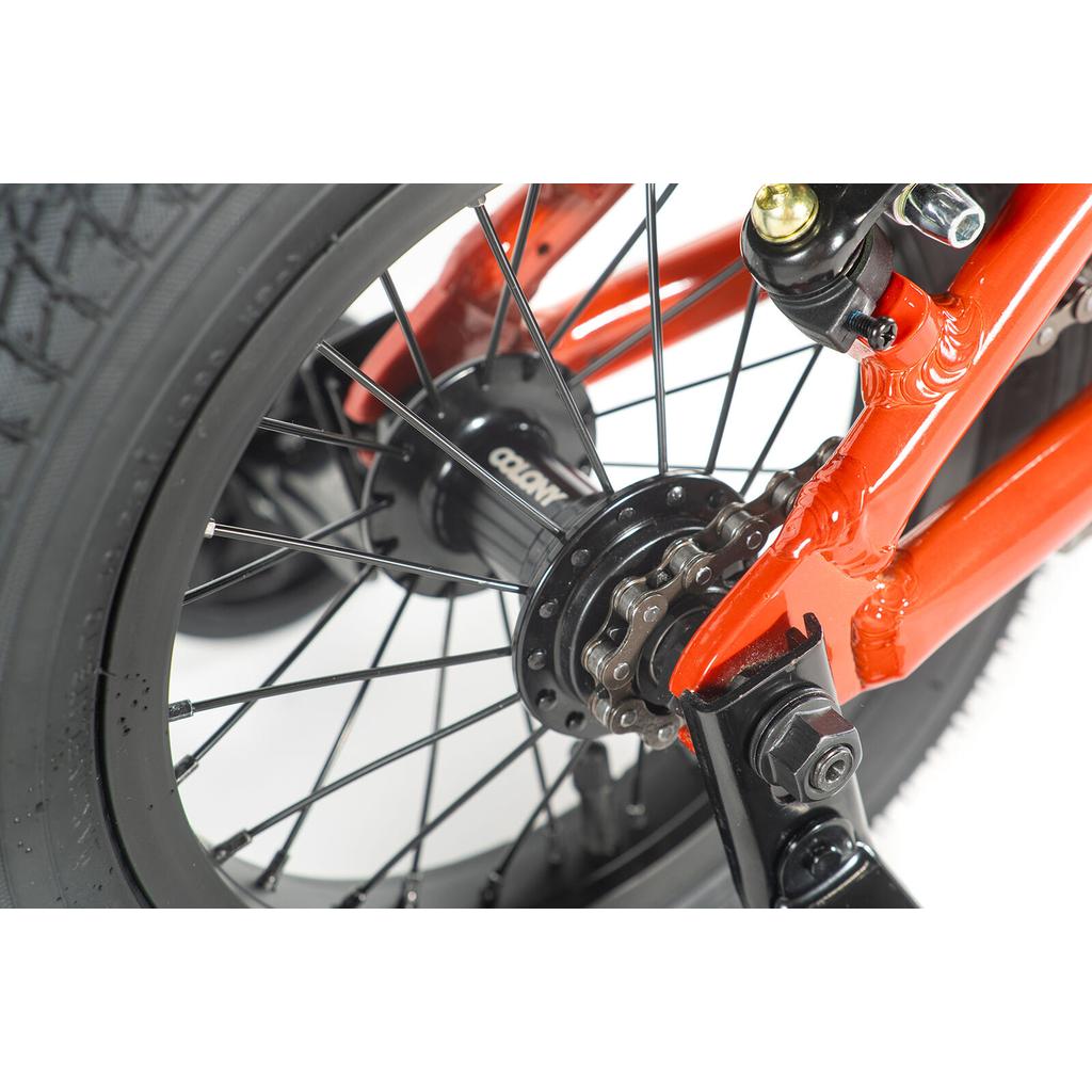 Close-up of the Colony Horizon 12 Inch Bike’s red rear wheel hub, showing spokes, gear cog, chain, lightweight alloy frame, and tire—all featured on a white background.