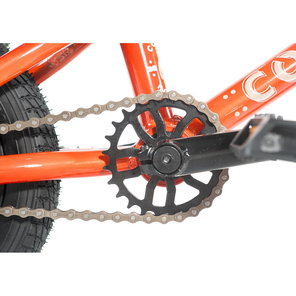 Close-up of a black crankset and chainring on an orange alloy frame, with tire and chain visible—ideal for BMX bikes such as the Colony Horizon 12 Inch Bike.