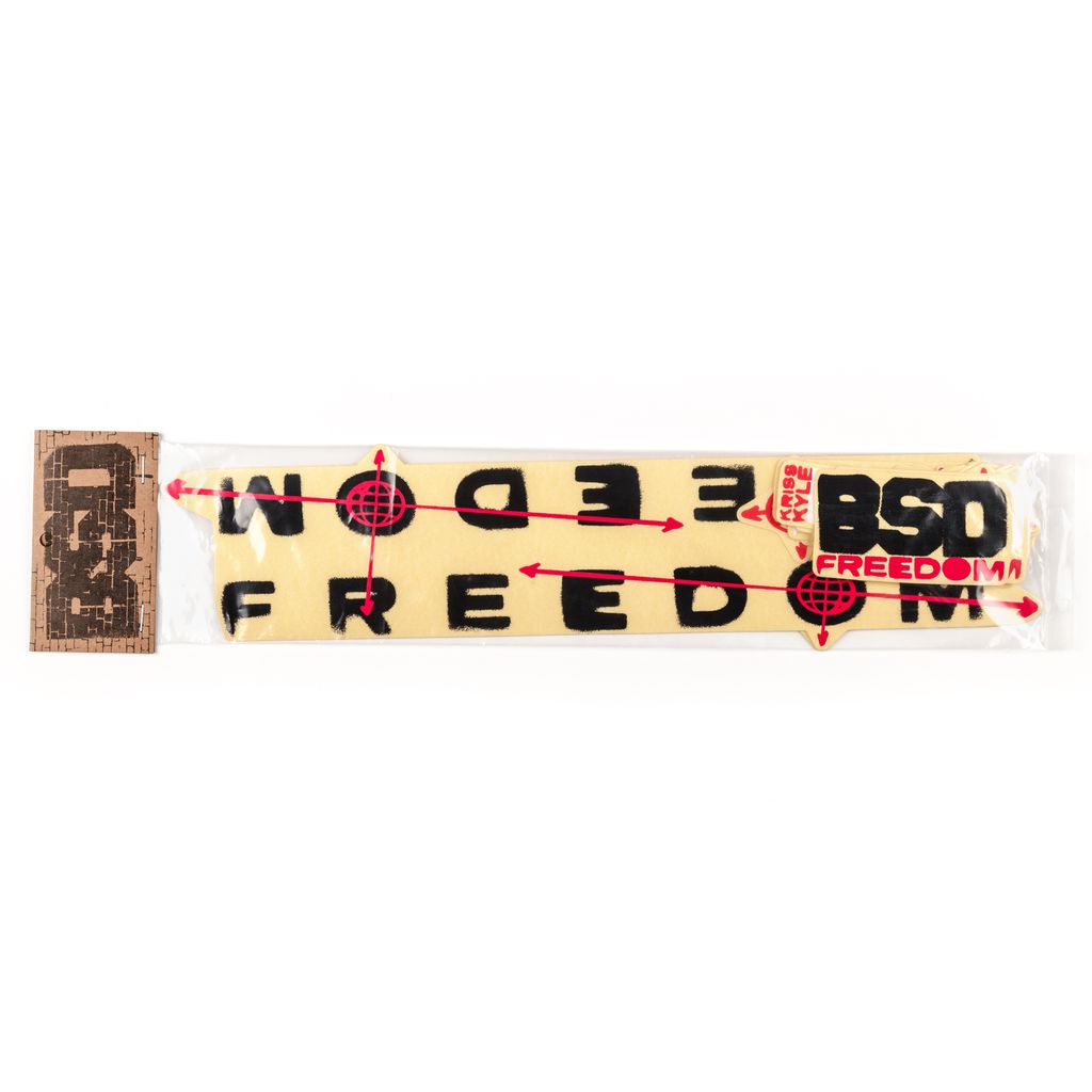 A packaged yellow headband featuring red and black text and designs, with the text reading "BSD Freedom Frame 2019 Decal Set" and showcasing arrow and target motifs. A beige and brown tag is attached.