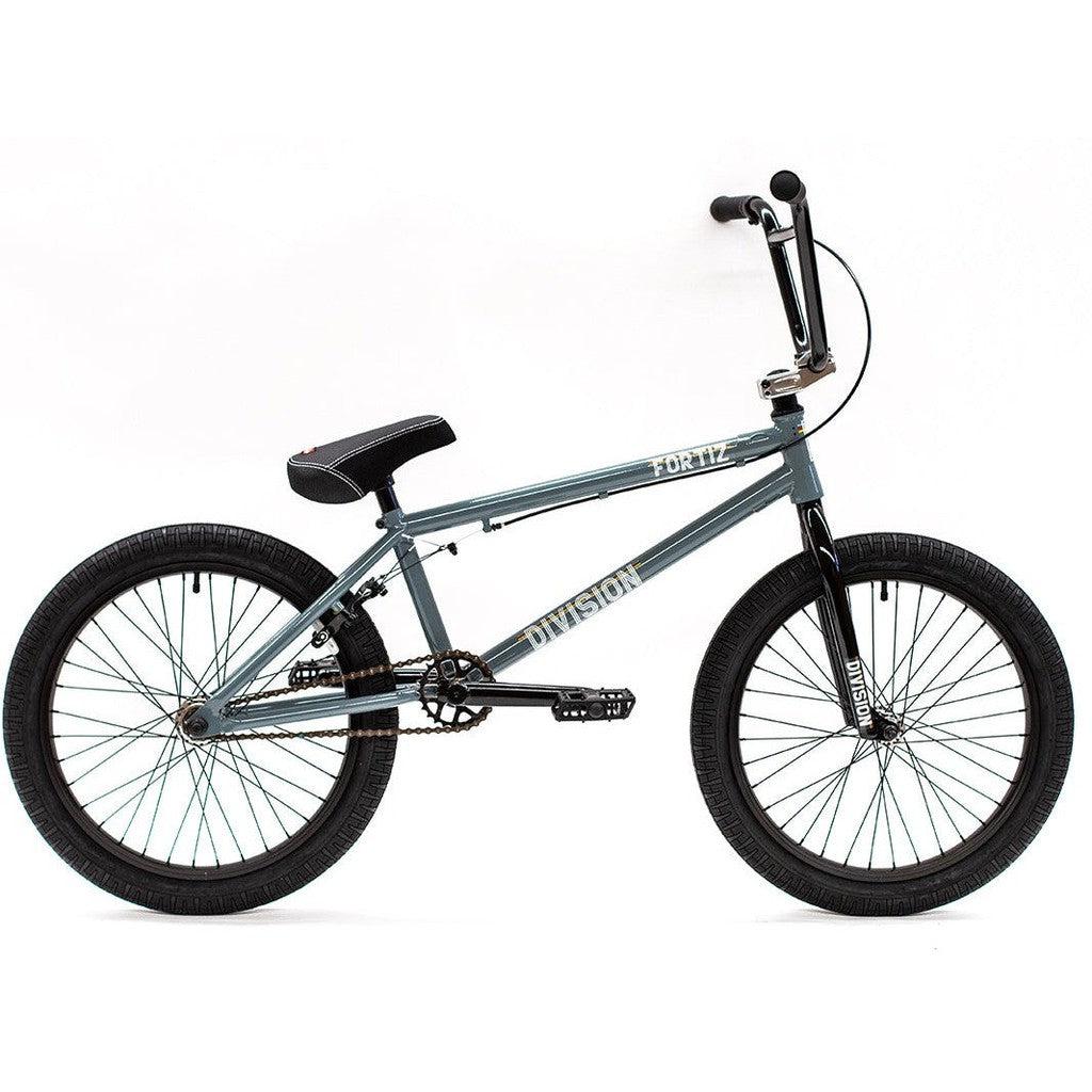 A gray Division Fortiz 20 Inch Bike with a black seat, handlebar grips, and tires. The Chromoly frame features the words "FOR 12" and "Division Fortiz" printed on it.