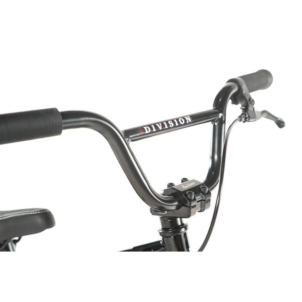 Close-up of black handlebars on a Division Blitzer 12 Inch Bike with "Division" elegantly etched on the horizontal bar, perfect for freestyle enthusiasts seeking style and performance.