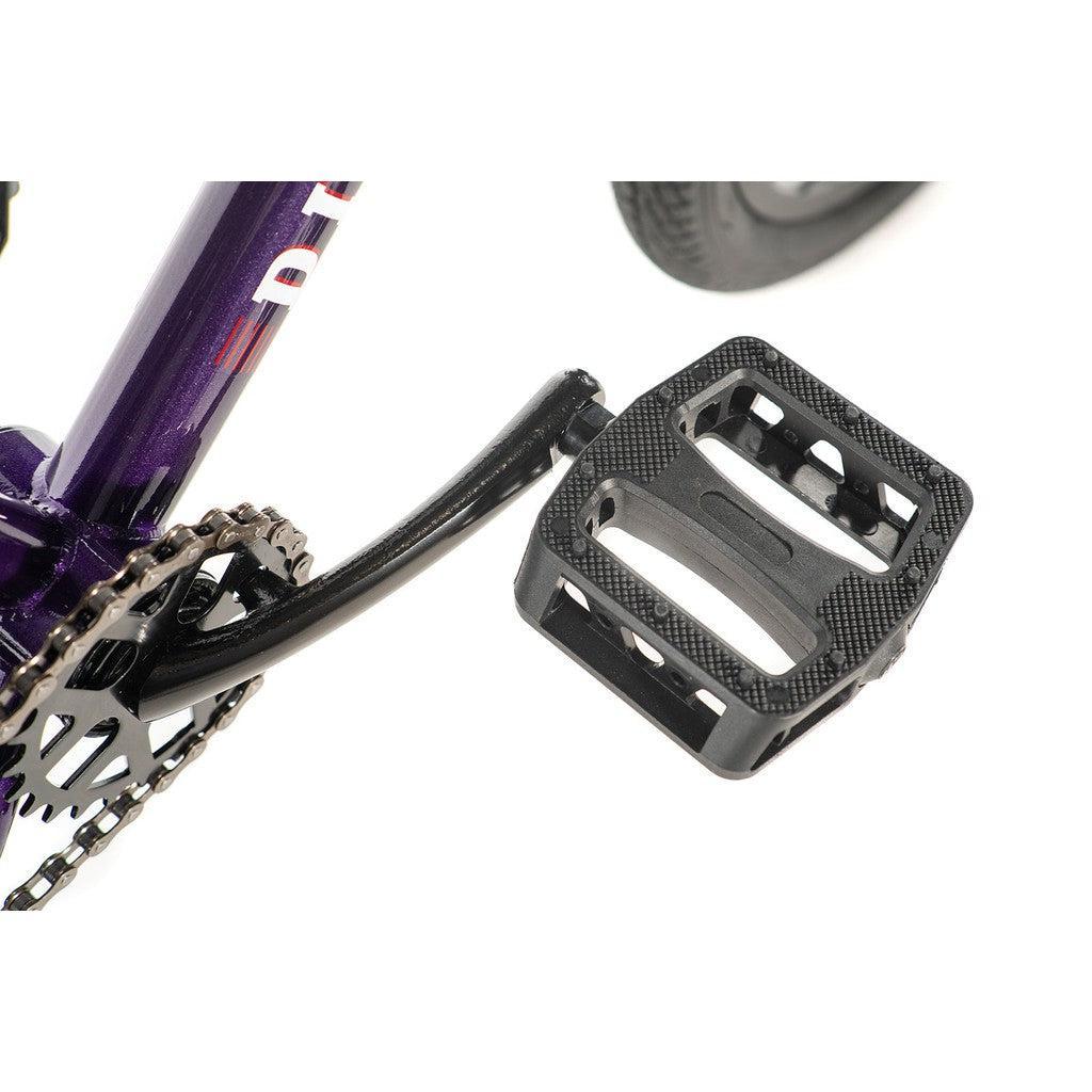Close-up of a bicycle pedal and chainring axle on the purple frame of the Division Blitzer 16 Inch Bike, showcasing its sleek, scaled-down geometry against a white background.