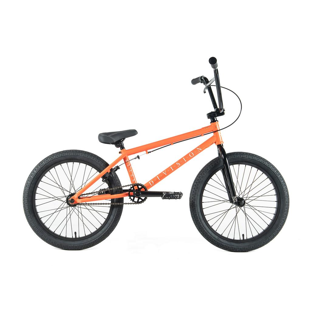 The Division Reark 20 Inch Bike in orange features a black seat, handlebars, pedals, and tires with a sealed bottom bracket. Shown from the side against a white background.