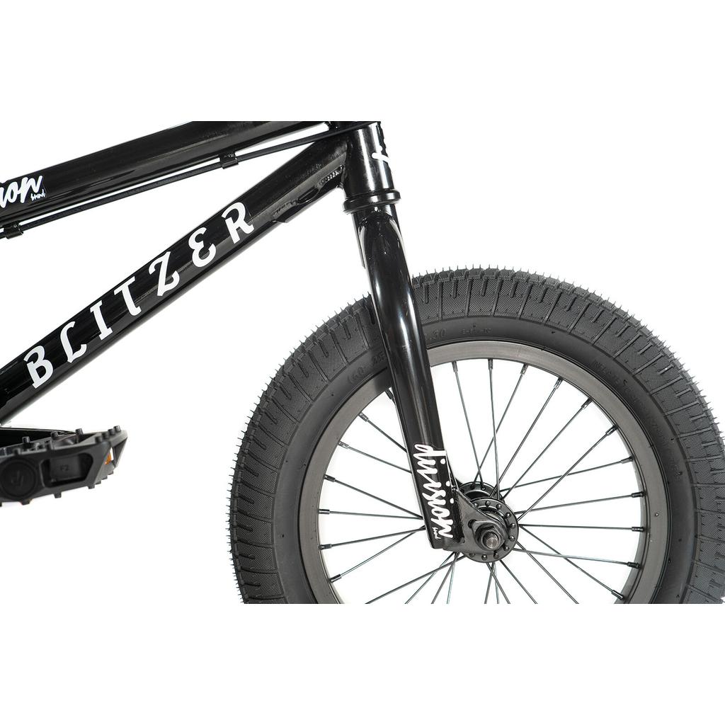Close-up of the front wheel, fork, and frame of the black Division Blitzer 14 Inch Bike, showing tire tread and spokes on its 14-inch wheels.