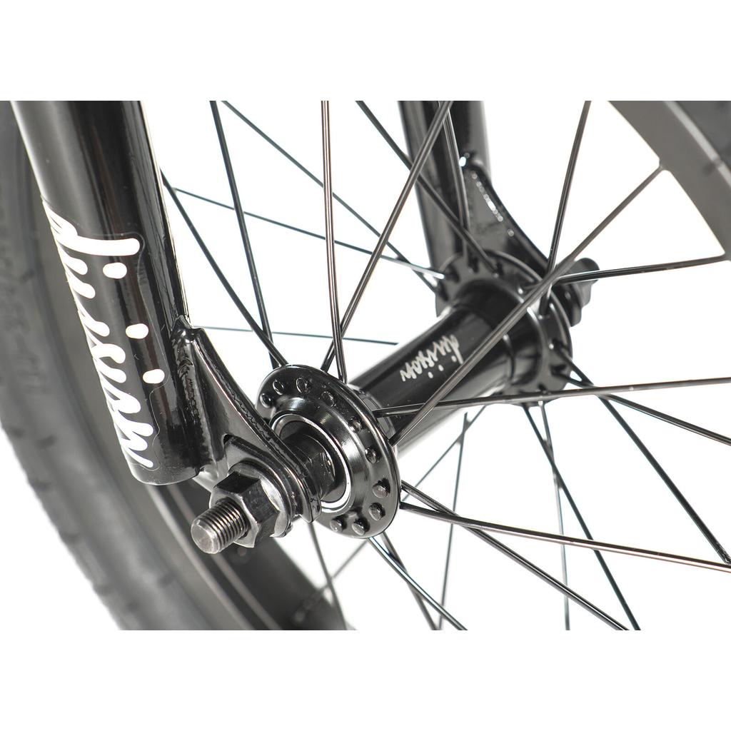 Close-up of the Division Blitzer 14 Inch Bike’s black BMX front wheel hub and spokes, attached to the fork with a visible axle bolt and white logo—ideal for kids’ BMX bikes with 14-inch wheels.