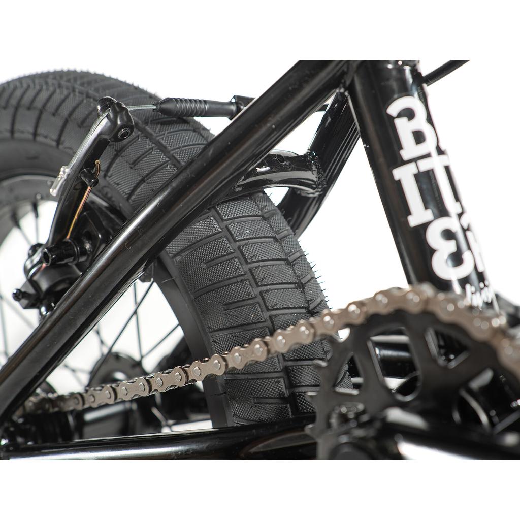 Close-up of the rear wheel, tire tread, brake, and chain of the Division Blitzer 14 Inch Bike.