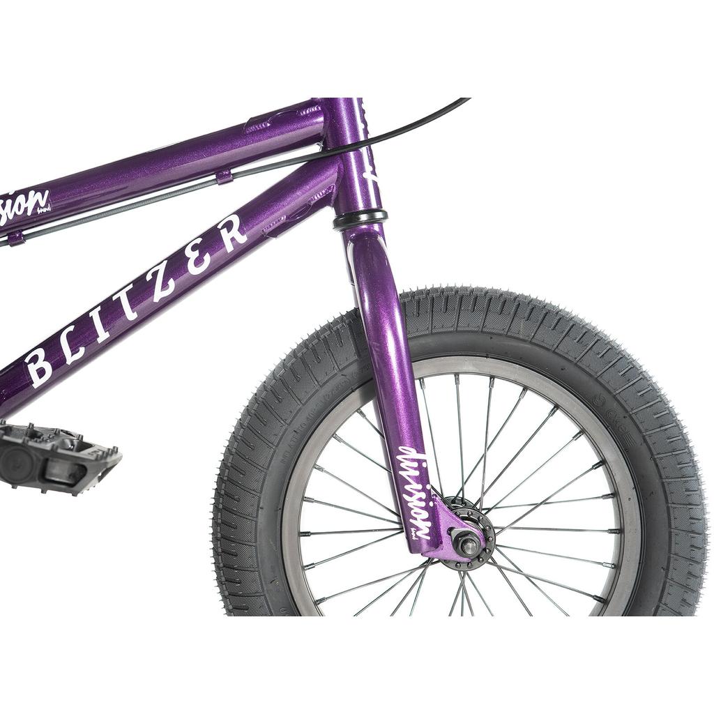 Close-up of the Division Blitzer 14 Inch Bike for kids, showing the purple BMX's front wheel, fork, pedals, and partial frame with "BLITZER" and "division" branding. Features 14-inch wheels suited for young riders.