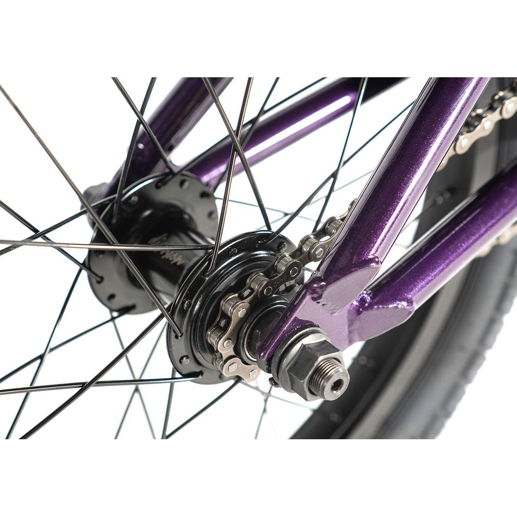 Close-up of the Division Blitzer 16 Inch Bike's purple rear wheel hub, displaying spokes, chain, and axle against a white background.