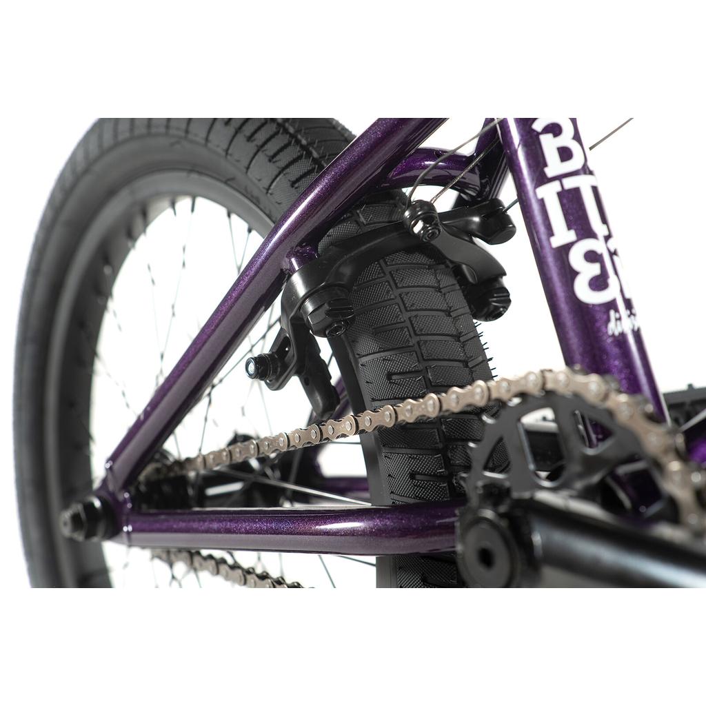 Close-up view of the rear wheel, tire, cassette hub, brake, and chain of the Division Blitzer 18 Inch Bike with a Hi-Ten frame.