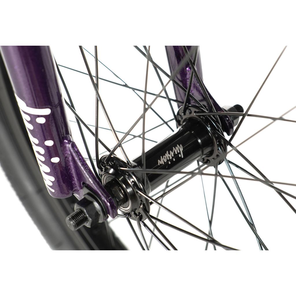 Close-up of the Division Blitzer 18 Inch Bike’s front wheel hub with black spokes, mounted on a purple fork. The hub features white text and stands out against the white background.