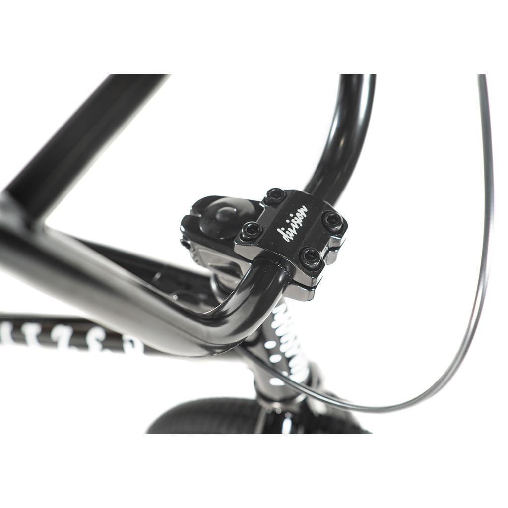 Close-up of a Division Blitzer 20 Inch Bike's black handlebar and stem assembly with visible bolts and cable, set against a white background—perfect for beginner street BMX riders.