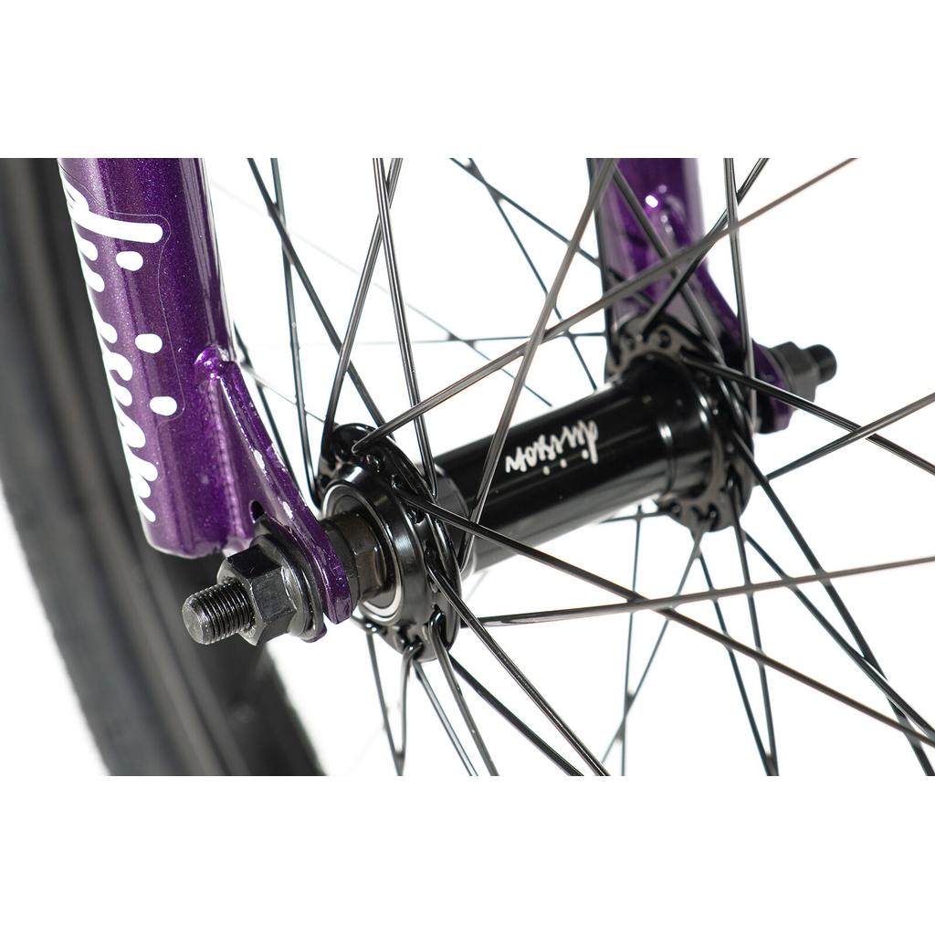 Close-up of the Division Blitzer 20 Inch Bike showing its black hub and spokes attached to a purple fork, visible axle bolts, and tire—ideal for beginner street BMX riders using 20” wheels.