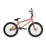 A side view of the Division Reark 20 Inch Bike in red, featuring black tires, black seat and handlebars, 3-piece cranks, and a lightweight Hi-Tensile steel frame, shown against a white background.