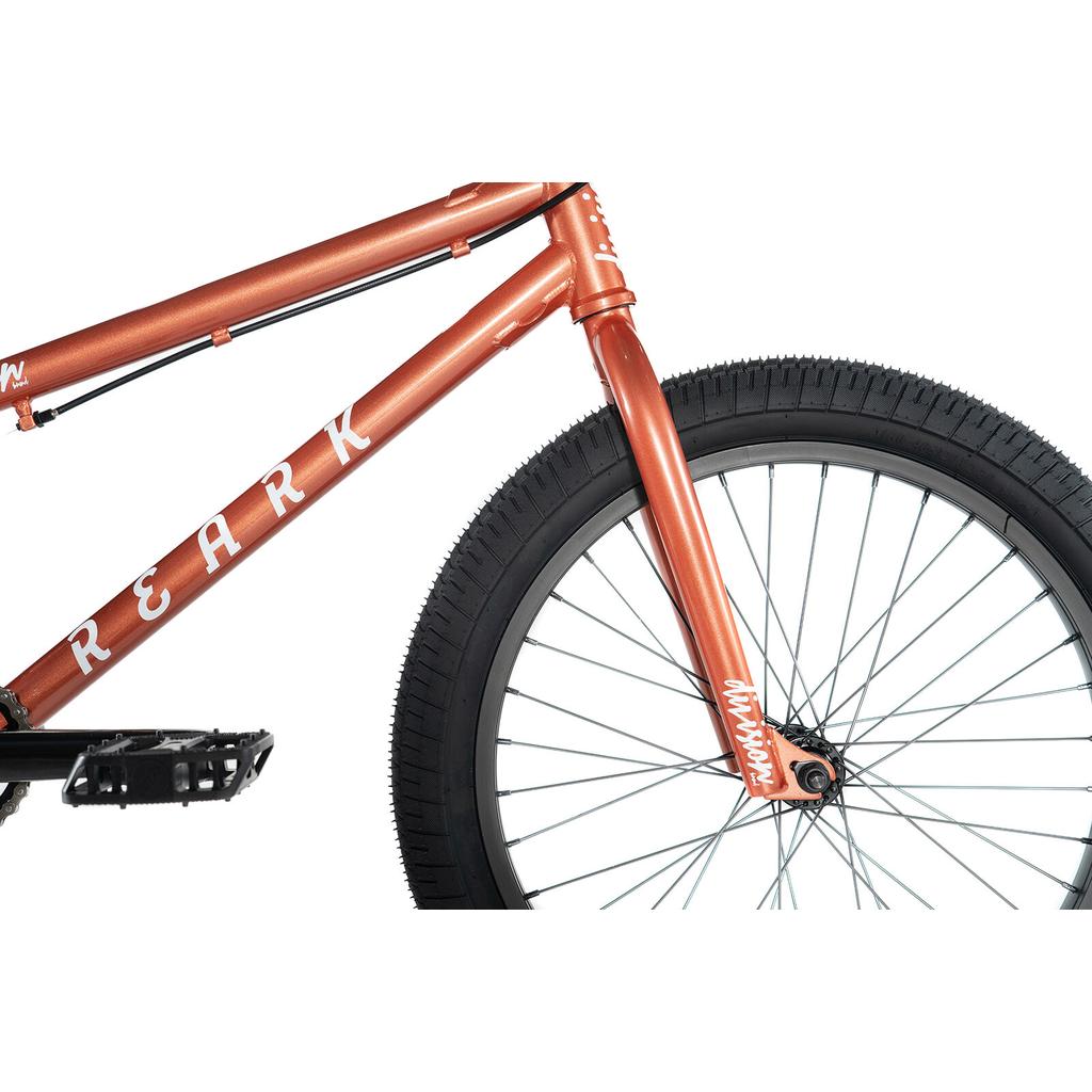 Close-up of the orange Division Reark 20 Inch Bike BMX, highlighting its lightweight Hi-Tensile steel frame and fork, front wheel, pedal, and sturdy 3-piece cranks.
