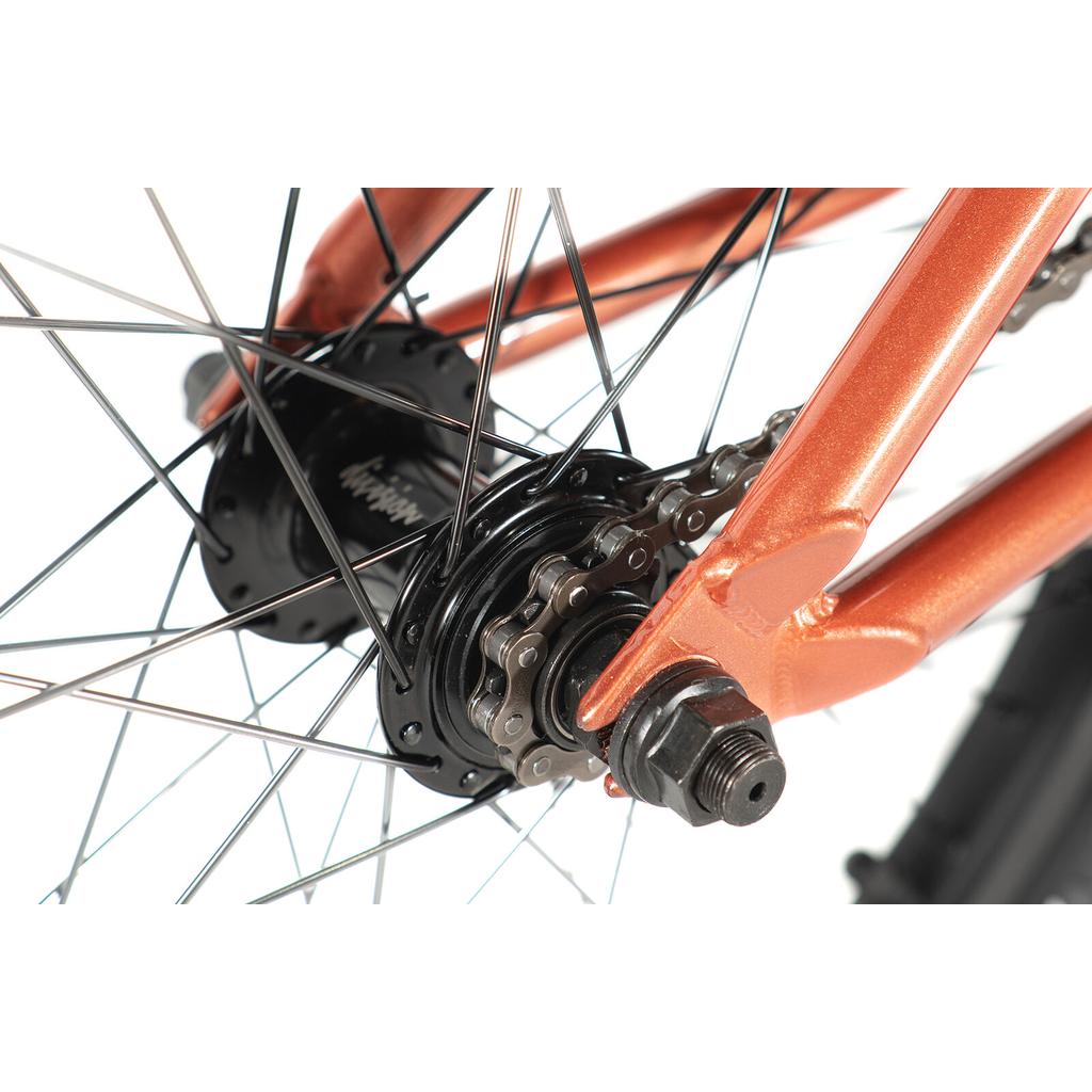 Close-up of the Division Reark 20 Inch Bike's rear wheel, highlighting spokes, hub, chain, orange frame with visible axle nut—all crafted from lightweight Hi-Tensile steel.
