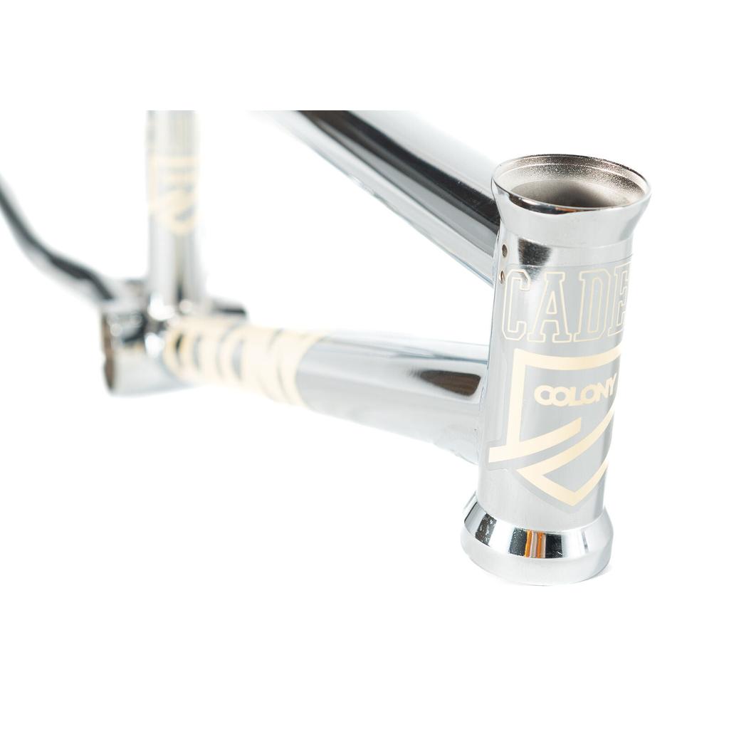 A close-up of the Colony Cadet 16 Inch Frame, a chrome BMX constructed from CrMo, with "CADET" and "COLONY" logos on the head tube and down tube.