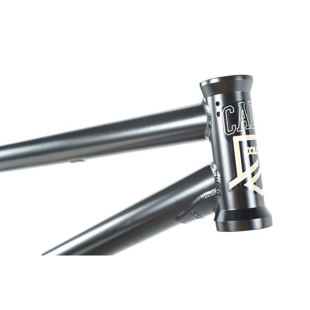 Close-up of the matte black Colony Cadet 18 Inch Frame, focusing on its welded chromoly joints and head tube featuring a white logo and lettering.