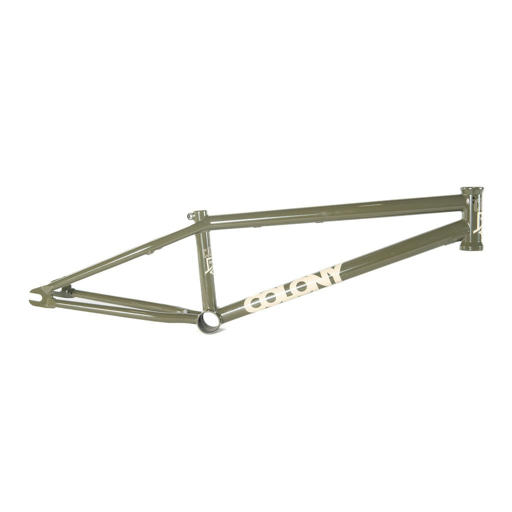 The Colony Cadet 20 inch Frame features an olive green chromoly build with "Colony" in white on the downtube, designed for park and street riding, shown on a white background.