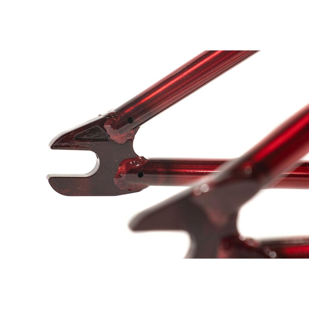 Close-up of a red metallic Colony Injustice Frame (Tom Justice Signature) 4130 CrMo BMX dropout against a white background.