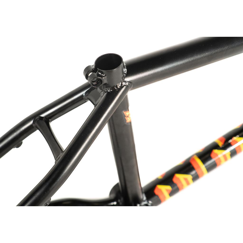 Close-up of a black Colony Balkan Eagle Frame (Renato Rancso Signature) with welded joints and vibrant orange and yellow graphics on the lower tube, set against a white background. This signature frame highlights both style and durability in its meticulous construction.