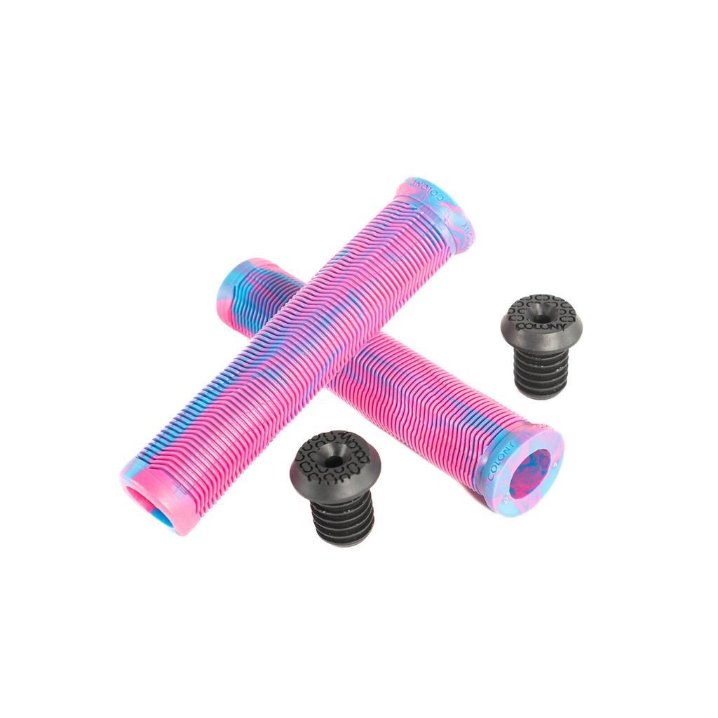 Two Colony Much Room Flangeless Grips in pink and blue crossed, with four black BMX bar ends placed nearby on a white background.