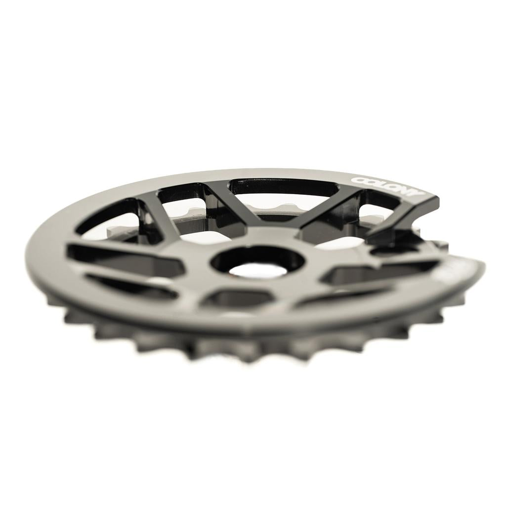 Close-up of the Colony Bish Guard Sprocket, highlighting its CNC machined black metal design with teeth along the edge and a logo on top. This lightweight sprocket enhances performance and style.