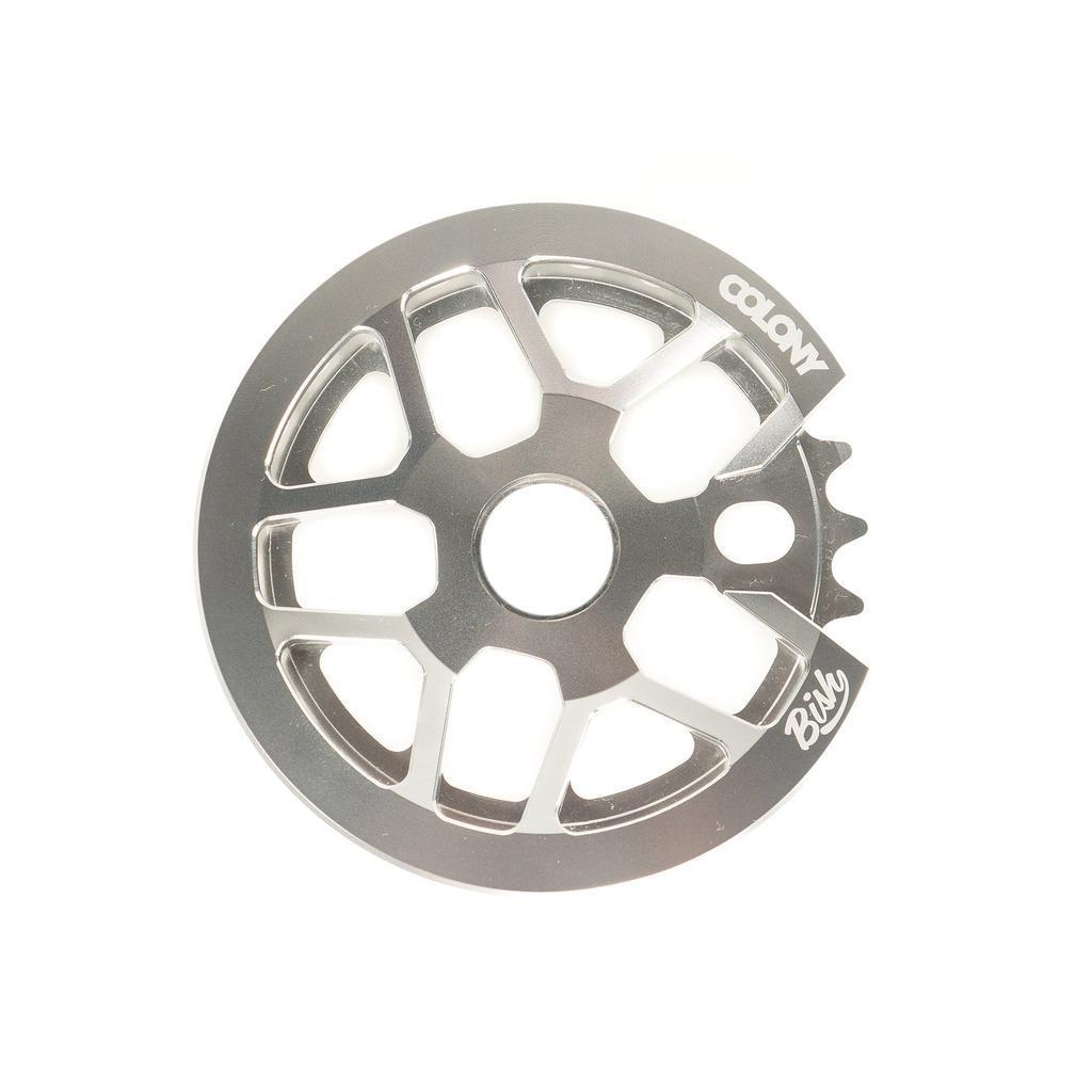 The CNC machined Colony Bish Guard Sprocket in silver showcases branded "Colony" and "BMX" engravings with a sleek guard for added protection.