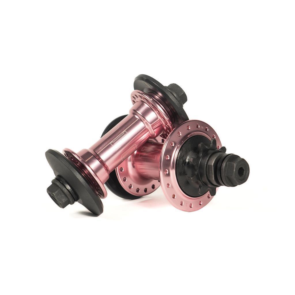 The Colony Wasp Hub Set in Rose Gold features two metallic hubs inspired by BMX design, with black bolt ends and spoke holes on a white background. High-performance sealed bearings deliver smooth, reliable riding.