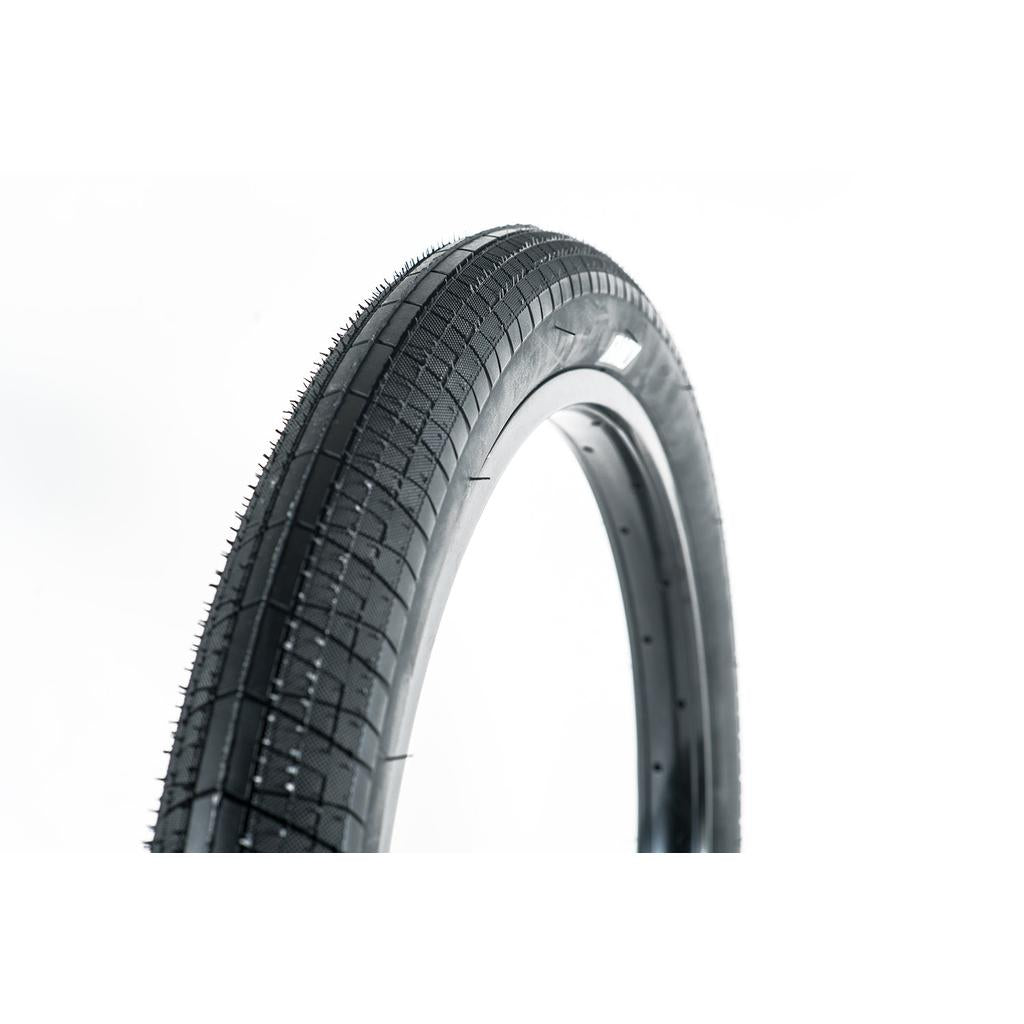 A close-up of the Family BMX F603 20 Inch Tyre in black stands upright against a white background, highlighting its tread pattern and manufacturing nubs—perfect for those seeking great value in a 20" bike tyre.