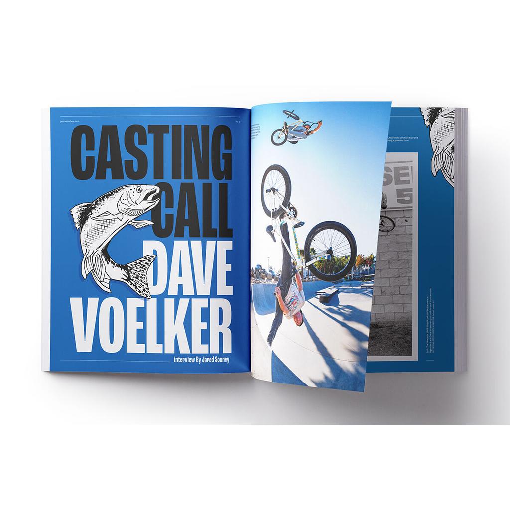 An open Grey Stoke BMX Magazine V4 displays a "Casting Call: Dave Voelker" feature with a fish illustration, while a BMX rider performs a trick on the next page—capturing the spirit of BMX history.